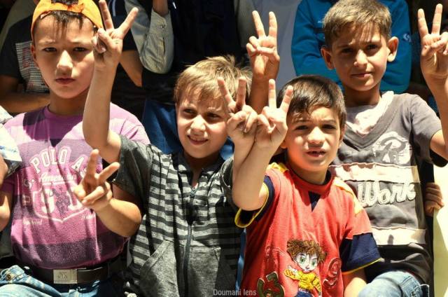 Des enfants lèvent le V de victoire à Douma